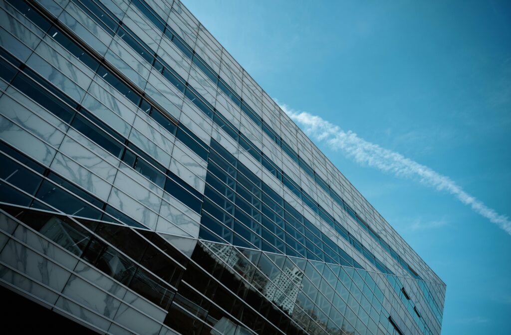 pexels photo 17631857 17631857 A striking low angle view of a modern glass building against a clear blue sky, emphasizing urban architecture.